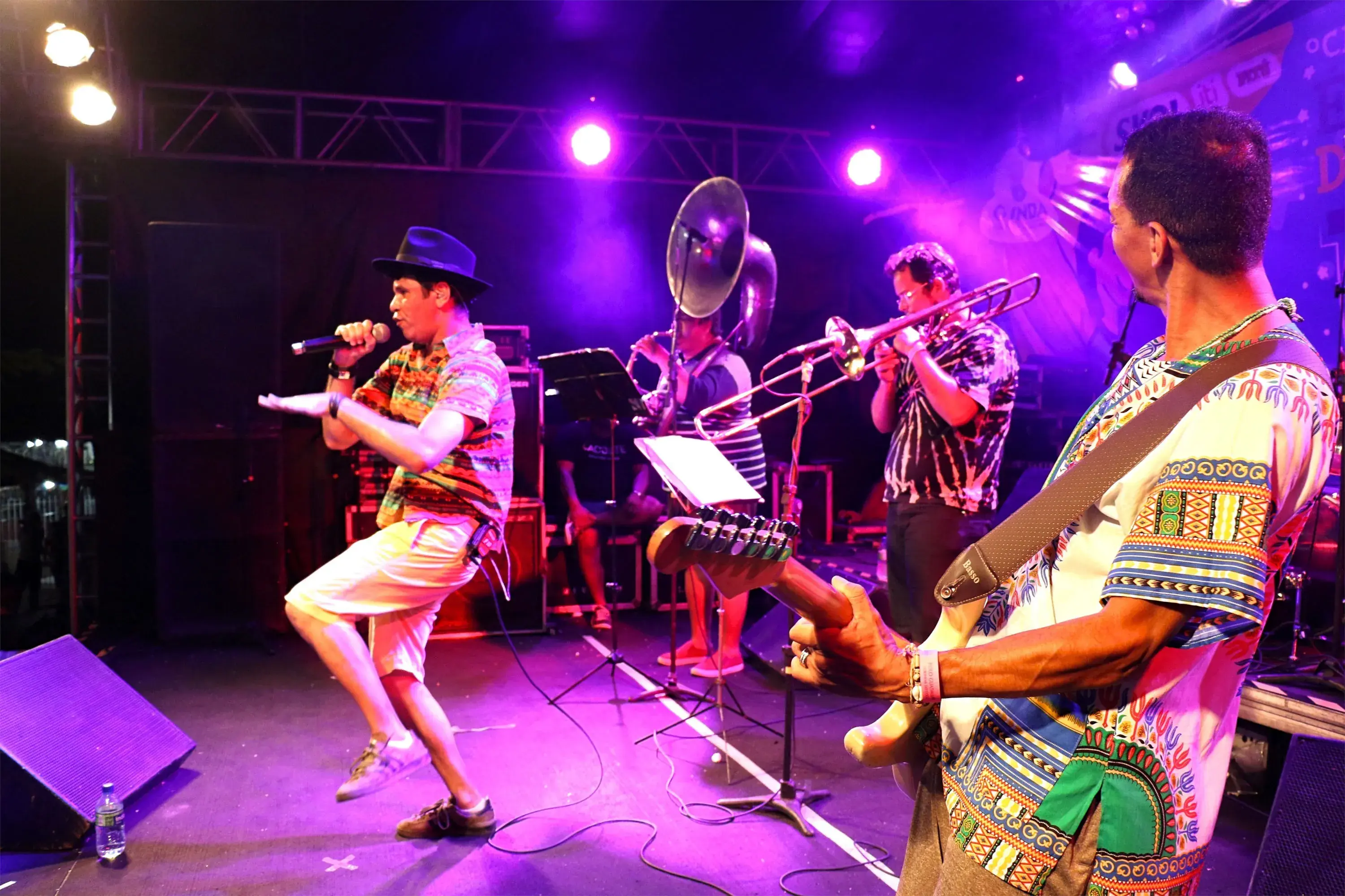 Alê Maia cantando e Hamilton Tenório na guitarra com a banda de fundo no show do caboclo mestiço.