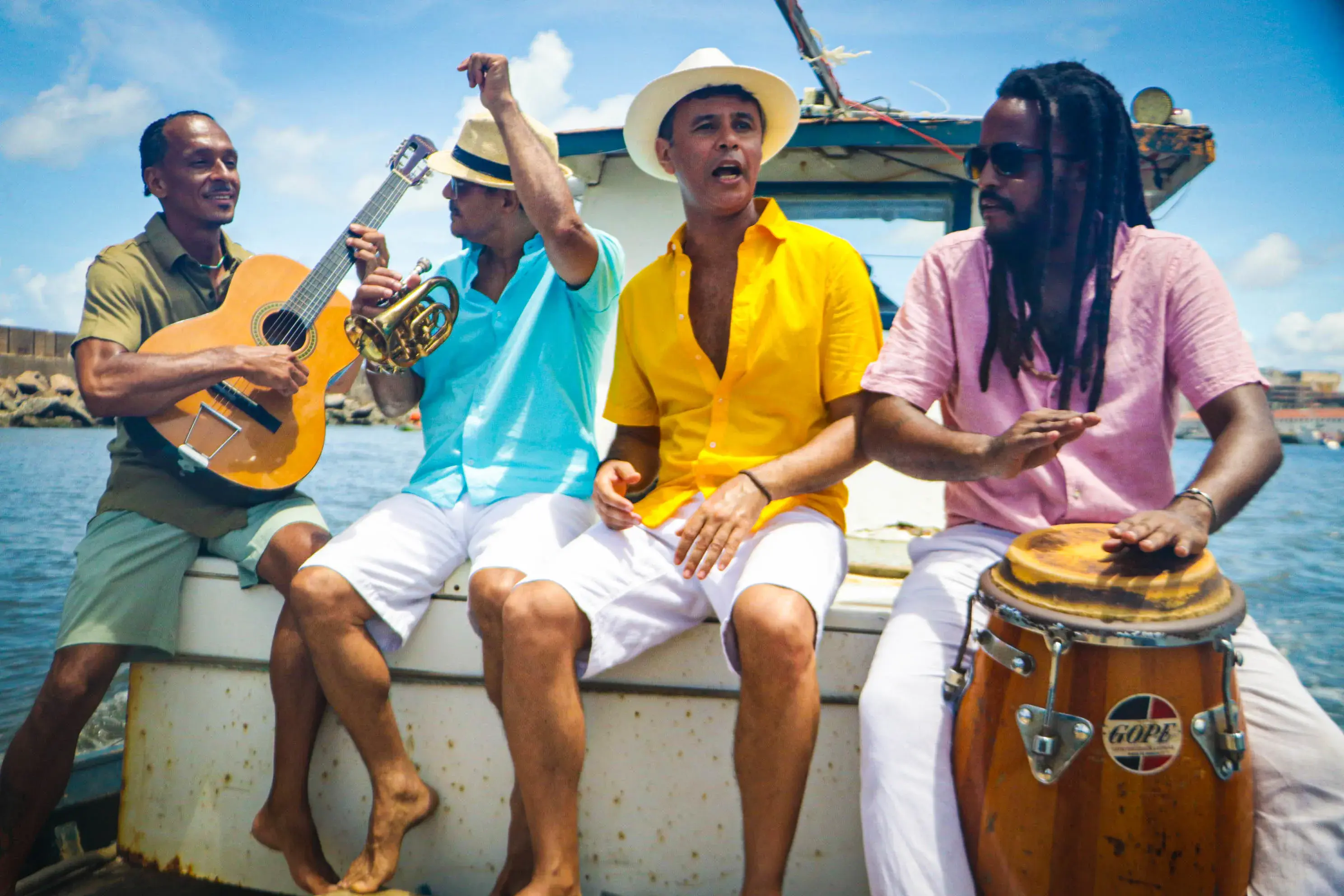 Hamilton Tenório, Roberto Patrício, Alê Maia e Arnaldo do Monte tocando num barco no mar.